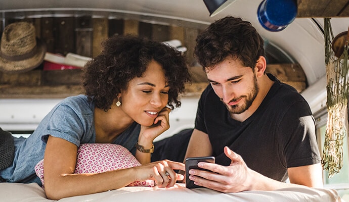 Egy férfi és egy nő egy mobiltelefonra néz